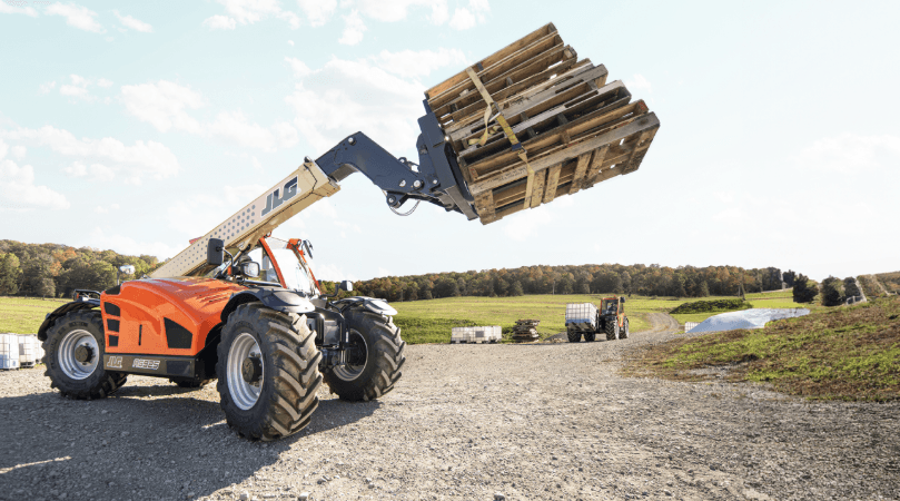 Telehandlers moving a stack of pallets