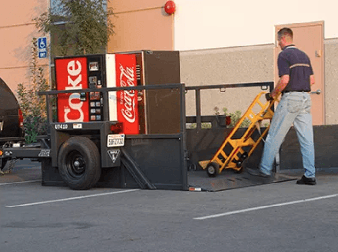 Man using drop deck trailer to load things