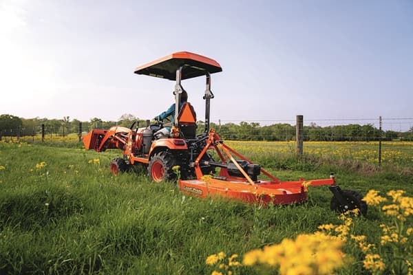 Man mowing lawn with rear mower