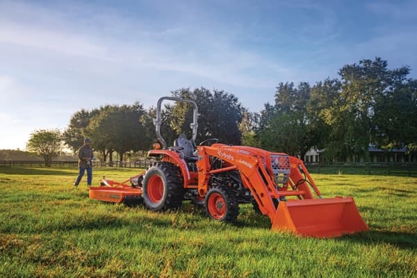 Man walking towards a tractor in a field
