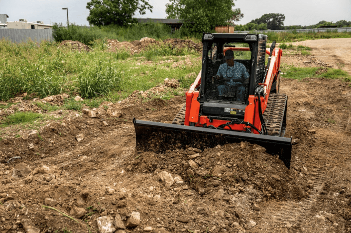 Loader moving dirt with front bucket